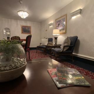 A cozy lounge area featuring comfortable seating, a decorative rug, and ambient lighting.