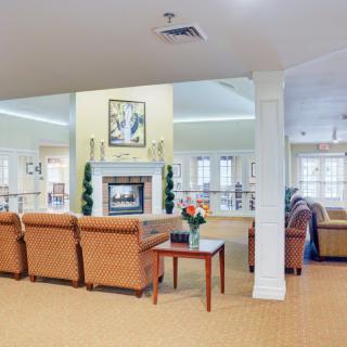 A spacious living room with comfortable seating and a central fireplace.