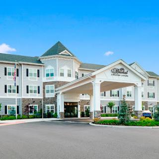A welcoming hotel entrance with a charming facade and landscaped surroundings.