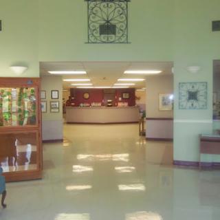 A spacious lobby with a reception area and exhibits displayed in glass cases.