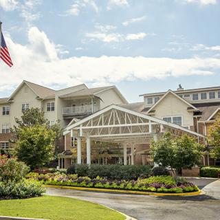 A well-maintained building with landscaped entrance and an American flag flying nearby.