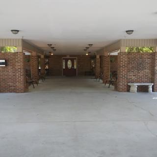 A spacious corridor with brick walls, benches, and overhead lighting.