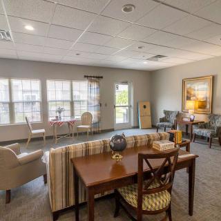 A cozy and well-lit living room with comfortable seating and large windows.