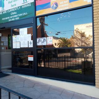 A storefront with large windows reflecting the surrounding area.
