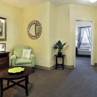 A cozy living room with a green armchair and decorative elements.