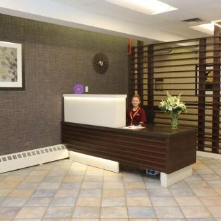 A modern office lobby with a reception desk, decorated with flowers and stylish wood paneling.
