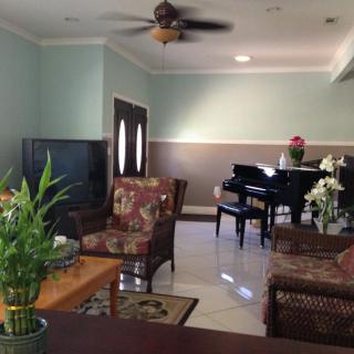 A cozy living room with a piano, television, and elegant decor.