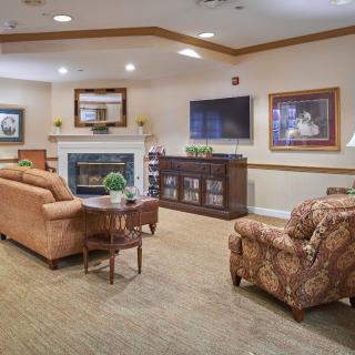 A cozy living room with sofas, a fireplace, and a television.