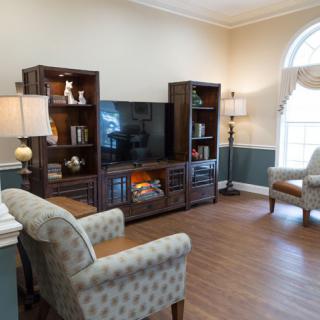 Cozy living room with a television, bookshelves, and comfortable seating.