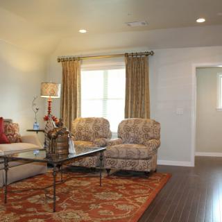 A cozy living room with patterned chairs and a decorative rug.