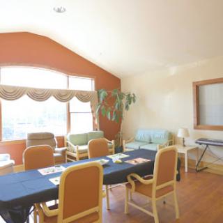 A well-lit meeting room with a long table and comfortable chairs, perfect for discussions and collaborations.