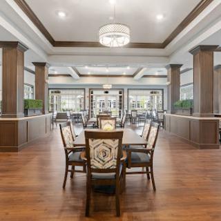 A modern dining area featuring elegant wooden furniture and abundant natural light.
