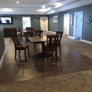 A modern dining area with tables and chairs arranged on laminate flooring.