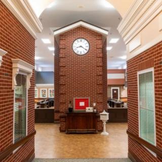 An indoor space featuring a large brick clock tower in a library setting.