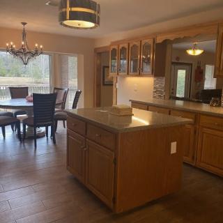 A spacious kitchen with an island and an adjacent dining area featuring a chandelier.