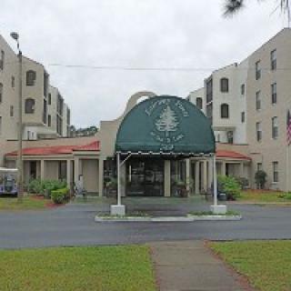 A multi-story building with an arched entrance and green awning.