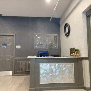 A modern reception area featuring a central desk with a wall clock and decorative elements.