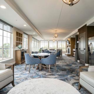A modern and elegant living room with ample seating, featuring large windows that allow for abundant natural light.
