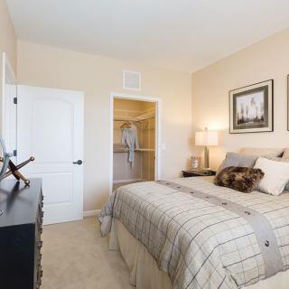 A cozy bedroom with a neatly made bed and soft lighting.