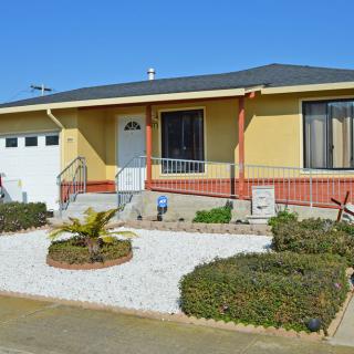 A single-story suburban house with a landscaped front yard and attached garage.