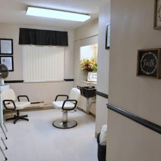 A cozy and well-lit salon waiting area with stylish chairs and floral decor.