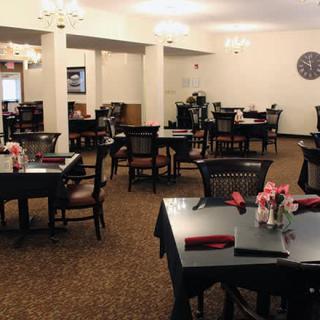 An empty restaurant dining area with neatly arranged tables and chairs.
