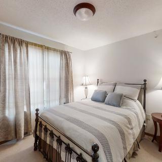A cozy bedroom with a neatly made bed and soft lighting.