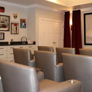A cozy home theater with comfortable seating and wall art.