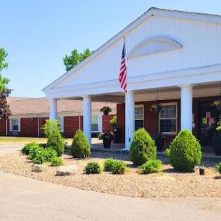 A charming residence featuring a welcoming front porch and well-maintained landscaping under a clear blue sky.