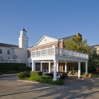 A building with a covered driveway and balcony.