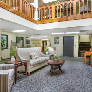 A cozy lobby with comfortable seating and a wooden staircase.