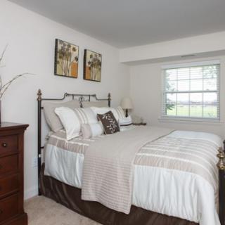 A cozy and inviting bedroom featuring a comfortable bed with elegant bedding and tasteful wall art.