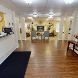 A well-lit lobby area with wooden flooring and comfortable seating.