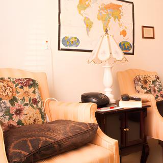 A cozy living room setting with two armchairs, a side table, and a world map on the wall.