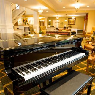 A grand piano elegantly placed in a luxurious hotel lobby.