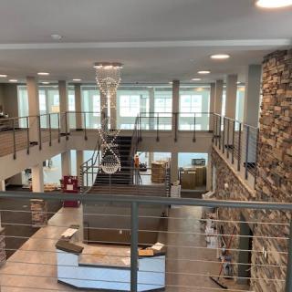 A modern office interior with an open layout featuring a mezzanine and stone accent wall.