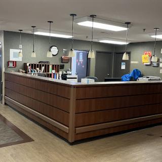 A modern reception area in a healthcare facility with wooden furnishings and bright lighting.