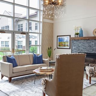 A modern living room with a cozy seating arrangement and large windows.