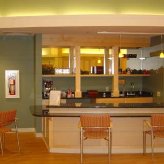A modern kitchen interior with a counter and bar stools.