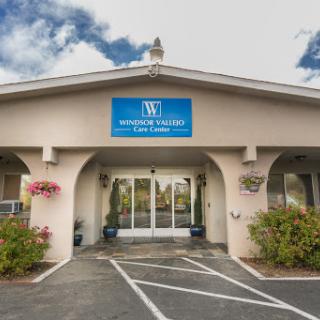 The entrance of a professional office building, featuring clear signage and landscaped surroundings.