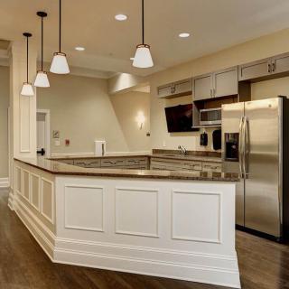 A modern kitchen featuring stainless steel appliances and elegant pendant lighting.