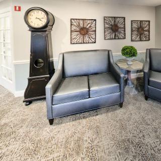 A cozy living room setting with cushioned seating and a standing clock.