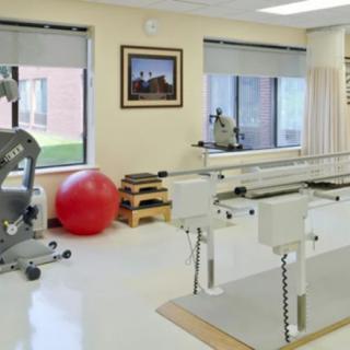 A physical therapy room equipped with exercise machines and a large gym ball.