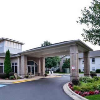 A welcoming entrance with a covered driveway and landscaped surroundings.