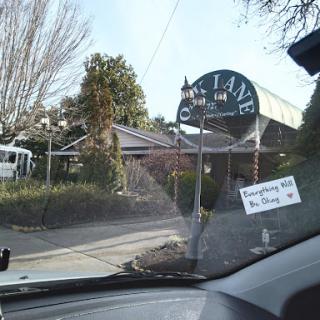 A view of a restaurant entrance from inside a vehicle.