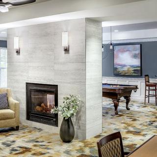 A modern living space featuring a fireplace, pool table, and contemporary decor.