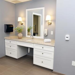 A modern bathroom vanity area with a large mirror and elegant lighting.
