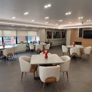 A contemporary dining area featuring modern furniture, artwork on the walls, and bright lighting.
