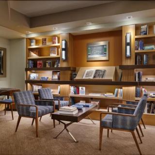 A cozy library with modern seating and well-organized bookshelves.