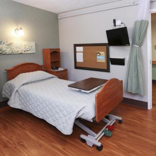 A hospital room with a bed, television, and modern amenities.
